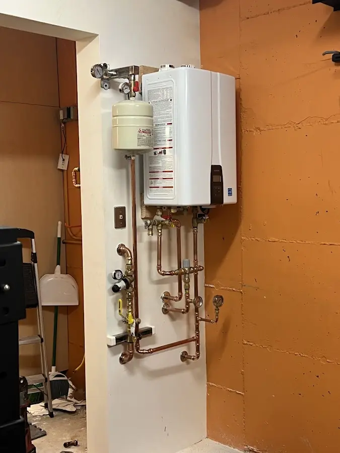 Plumbing technician inspecting water heater connections in Indianola
